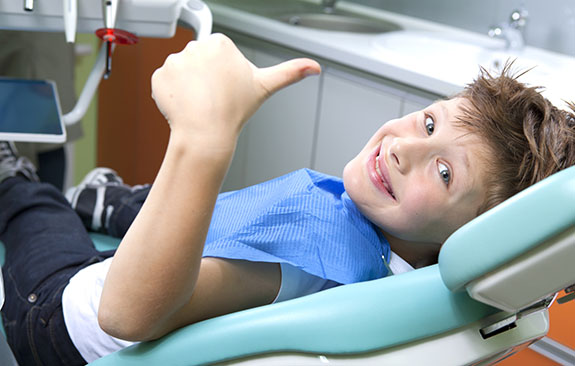child in dental chair with thumb's up | Dr. Wolnik